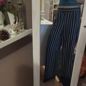 Randiga kostymbyxor  - Snygga svarta kostymbyxor med vita ränder från Bik Bok. Modellen är vid och har resor i midjan där bak för extra komfort. Väldigt sköna och i fint skick!🦝✨️ Det är bara att skriva om man har frågor!😊💖