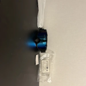 Svarta skidglasögon med blå spegelglas - Snygga skidglasögon med svart ram och elastiskt band. Linsen har en blå spegeleffekt som ger cool look och skyddar mot starkt ljus. Perfekta för dig som vill sticka ut i backen och få bra sikt i snön. Jag har använt den bara en gång. Och då behöver jag inte den längre för att jag använder inte den.