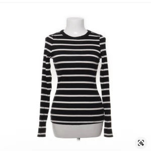 Randig långärmad tröja från H&M - Svart och vit ribbad långärmad tröja från H&M i storlek M. Tröjan har klassiskt horisontellt randigt mönster och är figurnära i modellen. Perfekt att styla med jeans eller kjol för en enkel och snygg look.