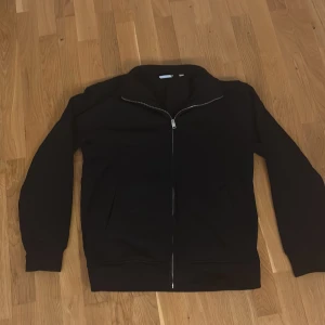 Svart zip-kofta från MNG - Svart kofta från MNG med hel dragkedja framtill och hög krage. Tröjan har långa ärmar, två fickor och är tillverkad i mjuk bomullsblandning. Perfekt för lite kallare väder och chill vardagsstil. Pris går att diskutera!