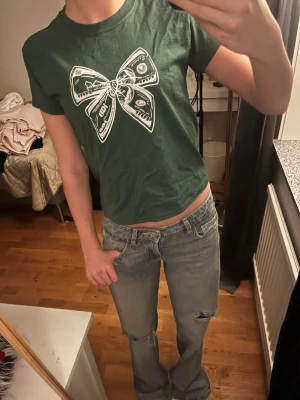 Söt grön T-Shirt - Gullig grön t-shirt i storleken XS ungefär, med en vit rosett på. Vet tyvärr inte märket.