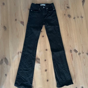 Svarta bootcut jeans från Zara - Snygga svarta/mörkgrå jeans från Zara i bootcut-modell med hög/medlehög midja. Klassisk femficksdesign och raka ben som släpper ut nertill. Storlek: 32. Nypris: 399kr