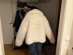 Vit fluffig pälsjacka med krage - Säljer en vit pälsjacka med bred krage och långärmad modell. Jackan har en oversized och loose passform som ger en cool och mysig vibe. Perfekt för dig som vill sticka ut med en riktigt fluffig jacka i vinter. Fråga gärna om fler bilder eller mått!