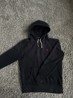 Mörk blå Ralph Lauren hoodie - En Clean hoddie från Ralph lauren som är i extremt bra skick tröjan är använd ett få tall gånger!!!                                                                               Hör av er om ni har några frågor!!🤩