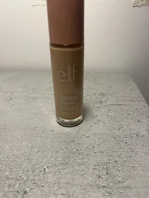 e.l.f. Halo Glow Liquid Filter Fair - Glow booster i flytande form från e.l.f. i nyansen Fair (Shade 0). Kommer i en genomskinlig glasflaska med beige plastlock och rymmer 31,5 ml. Ger en strålande finish och kan användas som foundation eller highlighter för extra glow. Säljer på grund av att de är fel färg! inte använd