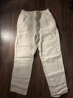 Vita linnebyxor (kostymbyxor) Zara - Snygga och luftiga vita linnebyxor från Zara i storlek S. Byxorna har elastisk midja, raka ben och är tillverkade i 100% linne. Perfekta för en chill och stilren look under varma dagar.
