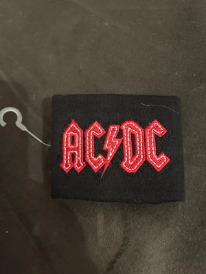 ACDC svettband med broderad text - Helt nytt svettband med broderat ACDC.