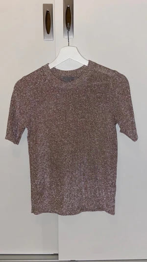 Glittrig champagne/lilafärgad topp från COS - Säljer en glittrig champagne/lila/ljusrosa-färgad topp från COS i storlek XS. Superfint skick!