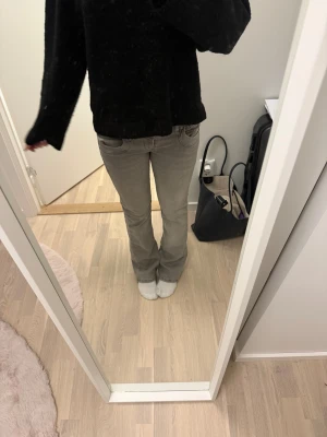 Grå bootcut jeans från LTB, 26/30 - Säljer ett par gråa jeans från LTB i storlek 26/30. Modellen har låg midja och bootcut-ben, vilket ger en snygg siluett. Jeansen har klassiska fem fickor och är tillverkade i mjukt denim-material. Perfekt för dig som gillar en chill och trendig look.