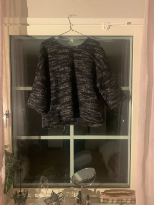 Svart och grå rutig kofta i ullmix - Säljer en oversized kofta i svart och grått med rutigt mönster. Koftan har trekvartsärmar och är tillverkad i en ullmix med nåt plastliknande på insidan. Perfekt för lager-på-lager och chill höst- eller vinterstil.🤍