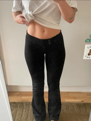Svarta bootcut byxor från Nelly - Low waist med knapp, utsvängda