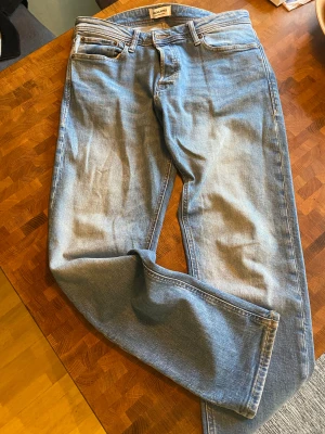 Ljusblå jeans Comfort/Mike Jack & Jones - Säljer ett par ljusblå Comfort/Mike jeans från Jack & Jones. Klassisk femficksmodell med raka ben och normal passform. Jeansen har snygga slitningar och är tillverkade i mjuk bomullsdenim. 