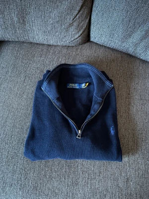Ralph Lauren Mesh-Knit Cotton Quarter-Zip - Marinblå quarter-zip från Ralph Lauren med blå broderad logga på bröstet. Den är k mycket bra skick. Endast använd ett fåtal gånger. Säljer den då den inte passar mig längre