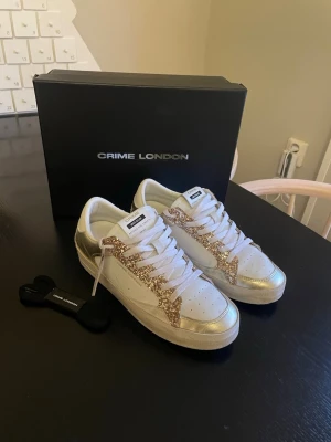 Sneakers från Crime London - Ett par sneakers från crime london i grymt skick. Dom har inte kommit till andväning och andvänt dom runt 10 gånger. Allt på bilderna ingår. Nypris 2000kr. Priset går att diskuteras vid snabb affär. 