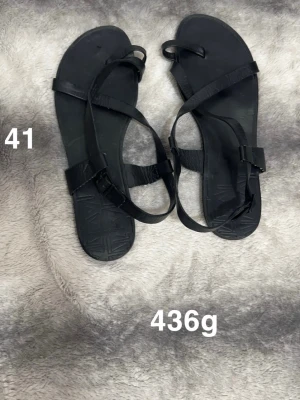 Svarta sandaler från Vagabond strl 41 - Svarta sandaler från Vagabond i storlek 41. De har tunna remmar i skinn och spänne vid ankeln. Snygg minimalistisk design med platt sula och geometriskt mönster undertill. Perfekta för varma dagar och enkel att matcha med olika outfits.🌸Fint använt skick. Storlek 41.