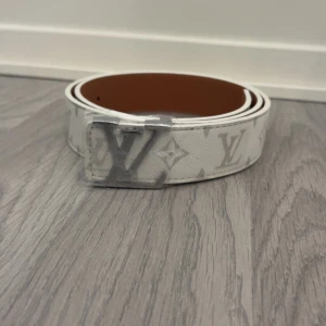 En vit bälte med L mönstrar på från Lindex - Ett snyggt fint vitt bälte från Lindex med L mönstrar på 