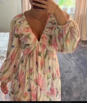 Blommig kortklänning  - Säljer denna populära Blommig långärmad kort klänning från H&M🩷använd fåtal gånger, skriv om ni är frågor 