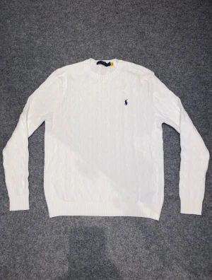 Vit kabelstickad tröja från Polo Ralph Lauren - Säljer nu min vita stickade tröja från Ralph Lauren. Den är väldigt skön och bekväm. Kvaliteten och skicken är väldigt bra!         Han på bilden är 172-174 cm.