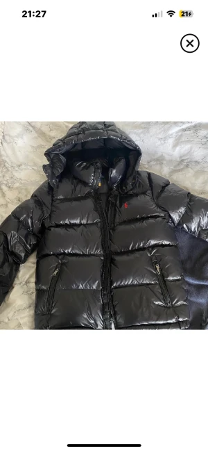SÖKER! Svart pufferjacka från Polo Ralph Lauren - SÖKER!!!Snygg svart pufferjacka från Polo Ralph Lauren med glansig finish och röd logga på bröstet. Är tjej och har S i storlek, nån som har en liknande med bra skick till salu? Kontakta gärna mig.
