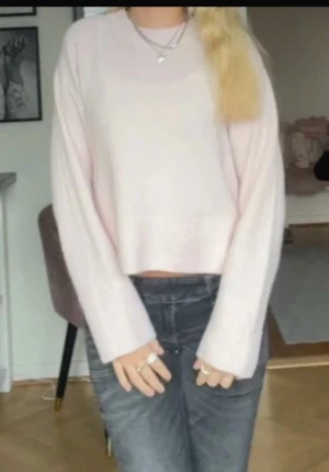 Ljusrosa stickad croppad tröja - Supermysig ljusrosa stickad tröja med croppad passform och långa ärmar. Perfekt att matcha med jeans eller kjol för en chill och snygg look. Tröjan har en enkel design utan mönster och är riktigt skön att bära. Den är endast använd 1 gång storlek 146-158