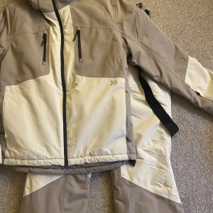 Beige och vit vindjacka från 157 - Skidjacka och skidbyxor! Säljer dem tillsammans för 300. Använda en gång! Storlek S!