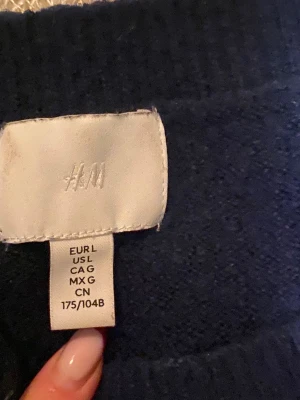 Mörkblå stickad tröja från H&M -  mörkblå stickad tröja från H&M i storlek L. Tröjan har en klassisk rund hals och utsvängda ärmar. Sitter som en M