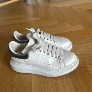 Alexander McQueen vita Sneakers - Säljer mina fina Alexander McQueen sneakers med silver detaljer. Köpa för två år sedan men varsamt använda. Köptes för 5000 kr. Kom med bud! Möts helst upp i Sthlm annars skickar jag. 