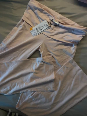 Ljusrosa yoga pants från Gina Tricot - Säljer ett par ljusrosa yoga pants från Gina Tricot i storlek 170. De har låg midja och är tillverkade i mjuk bomullsmix. Byxorna har utsvängda ben och är perfekta för en chill och avslappnad stil. Även nya med prislapp!