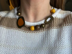 Unikt halsband med gula och bruna detaljer - Säljer ett coolt halsband med oregelbundna metallformer i antikguld och inslag av gul och brun färg. Kedjan är mörk och har stora pärlor i gult, brunt och metall. Perfekt för dig som gillar statement-smycken med konstnärlig vibe.  Halsband ihopsatt och omgjort av delar från vintage smycken, 70-90tal (skick därefter) helt unikt och one of a kind.  (Eftersom det är vintage så förekommer defekter och slitage så som exempelvis missfärgningar, se bilder)