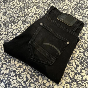 G-Star Raw jeans - Svarta slim/skinny jeans från G-Star RAW med klassisk femficksdesign och diskret logga på bakfickan. Jeansen är tillverkade i stretchigt denim för en bekväm passform och har snygga detaljer vid fickorna. Nypris: ca 1500kr, mitt pris 300kr!
