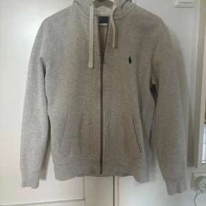Ralph lauren zip hoodie - Säljer min gråa Ralph Lauren tröja eftersom den är för liten. Sparsamt använd och den har inga fläckar eller slitage. Storlek M men jag har medium egentligen och den är lite liten för mig. Nypris: 2095kr 