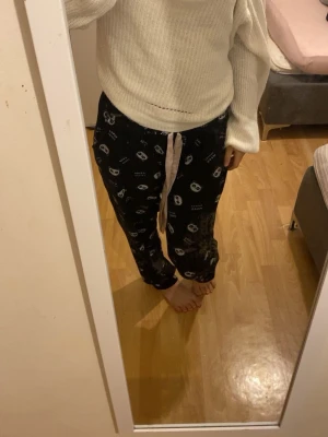 Vit stickad offshoulder tröja - Säljer en vit stickad tröja med offshoulder-design och breda, långa ärmar. Tröjan har en avslappnad passform och är ribbstickad med en liten dekorativ hålrad vid midjan. Perfekt för dig som gillar en chill och trendig stil.