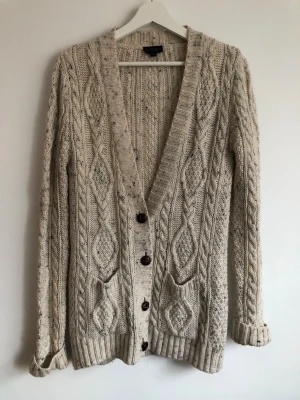 Flätstickad kofta i 58%ull - Naturvit stickad kofta från topshop, i ullmix. Varm och go!