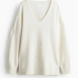 Vit stickad v-ringad tröja - Mysig vit stickad tröja från H&M, med v-ringad hals och långa ärmar. Tröjan har en loose passform och ribbade muddar vid ärmslut och nederkant. Perfekt för lager-på-lager under kyliga dagar.