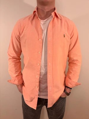 Rosa Ralph Lauren skjorta - En stilren skjorta från Ralph Lauren. Second hand men i väldigt fint skick ✨ Tvättad och struken – redo att användas direkt.  Riktigt snygg för många olika tillfällen såsom fest eller i vardag. Vinter eller sommar men bäst på vår/sommar. Inga defekter och regular fit.  Storlek 👔: S Nypris 💰: ca 1 300 kr 