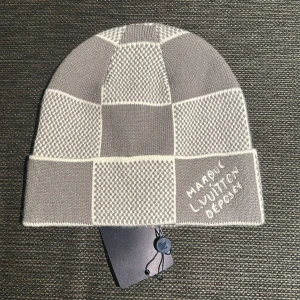 LUIS VUITTON MÖSSA - Snygg grå och vit rutig mössa. Mössan är stickad och har klassisk -tag på insidan. Perfekt accessoar för dig som gillar exklusiv streetstyle.