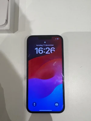 iPhone 14 - Snygg iPhone 14 i svart med originalkartong. Telefonen har dubbla kameror och modern design. Skärmen och baksidan visar fingeravtryck och lättare ytslitage, men inga synliga sprickor. Perfekt för dig som vill ha en kraftfull och pålitlig mobil. 128 GB