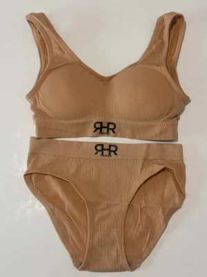 Beige BH Set från RHR Sweden - Säljer en beige set från RHR Sweden med svart logotyp framtill. Size S M L