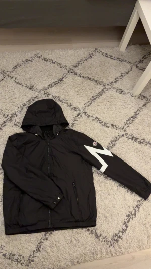 Moncler windbreaker  - Säljer nu denna svarta windbreaker från Moncler med huva och dragkedja framtill då den inte faller mig i smaken längre. Använd ett fåtal par gånger bara. Storlek L men passar även M. Pris kan diskuteras vid snabb affär. tags medkommer även! 