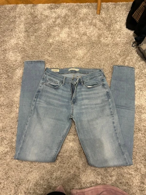 Levi's 710 Super Skinny ljusblå jeans - Säljer ett par Levi's Premium 710 Super Skinny jeans i ljusblå tvätt. De har klassisk femficksdesign, skinny passform och är tillverkade i stretchigt jeanstyg för en tajt look. Strl M