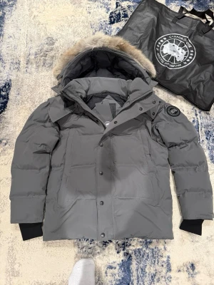Grå Canada Goose Wyndham L - Tja! Säljer denna as feta gråa canada goose Wyndham jackan med black lable i nyskick. Jackan är aldrig använd. Inget kvitto finns! Storlek L, han på bild är 185cm, 75kg. Hör av er vid funderingar!
