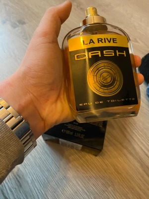 La Rive Cash Eau de Toilette - La Rive Cash Eau de Toilette för män, 100 ml. Tillverkad i Polen. Ingredienser: alkohol denat, aqua, parfum, etylhexylmetoxycinnamat, citrusolja, eugenol, vanillin, menthol m.fl. Modern design med guldiga detaljer.