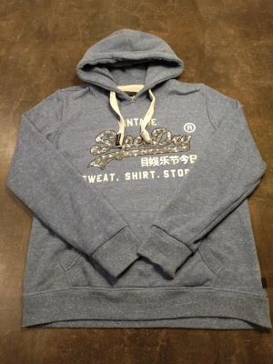 Superdry Hoddie  - Fin superdry Hoddie i toppskick. Modellen på bilden är 175 och den passar perfekt.