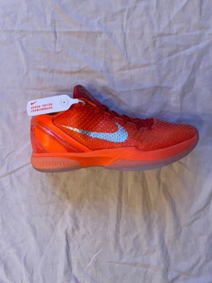 Nike Kobe 6 Protro total orange  - Nike Kobe 6 Protro total orange sneakers i orange med silverfärgad Swoosh och Kobe-logga på plösen. Kobes är små i storleken, rekommenderar att du har 43 om du köper denna. Jag har använt den i 1 månad men skadade mig - så ska sluta. Därför säljer jag dessa. Ni får kartong och den där vita grejen om ni vill