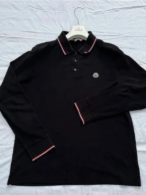 Moncler Långärmad Piké  - Säljer denna långärmade Moncler pikén i nyskick! Nypris 4000, mitt pris 1459! Size M! Hör av dig vid eventuella funderingar!