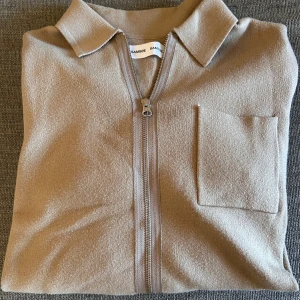 Beige overshirt från Samsøe - Stilren beige overshirt från Samsøe med klassisk krage, bröstficka och hel dragkedja framtill. Jackan är i ett mjukt material och har långa ärmar,  Perfekt för lager-på-lager och enkel att matcha. Nypris 1299kr, hör av er vid intresse/ frågor!