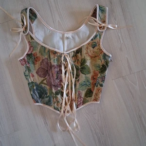 Blommig korsett💐🌷✨️ - Säljer en vintageinspirerad korsett. Bara använd ett fåtal gånger. Säljer pga att den inte är min stil längre. Köparen står för frakten. Hund finns i hemmet!🐕