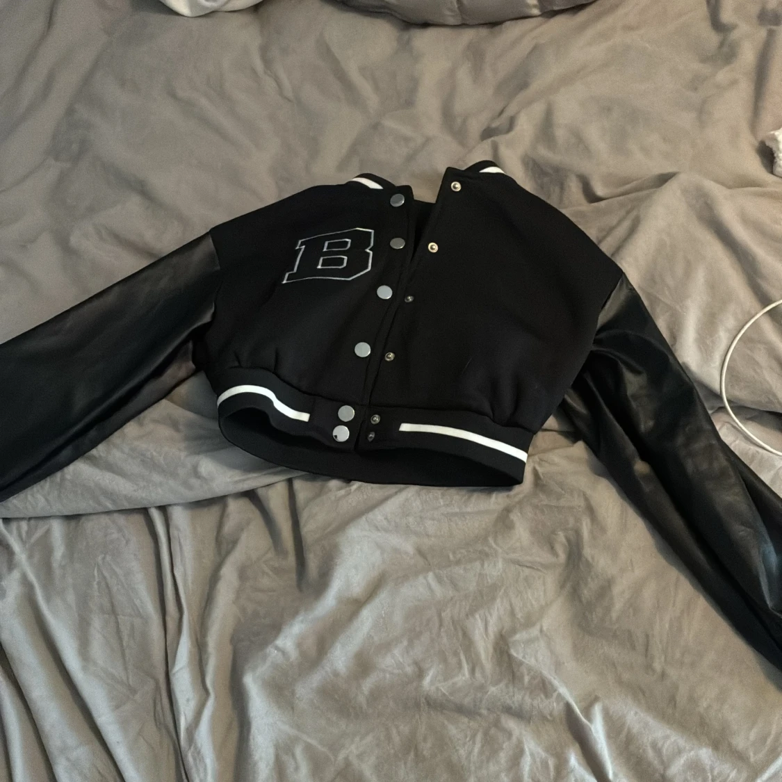 Svart bomberjacka med skinnärmar