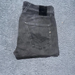 Replay jeans - Svarta Replay Hyperflex Anbass jeans med slim fit och klassisk look. Längd 102cm, midja 38cm. Ifall det inte finns någon bild i annonsen där jag bär plaggen jag säljer så är det för att jag ej kan ha storleken heller passformen, så kolla måtten för storlek och googla på modellnamnet för passform 😉