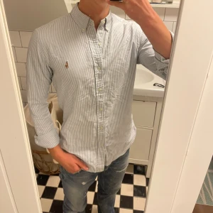 Randig skjorta från Ralph Lauren - Klassisk ljusblå och vit randig skjorta från Ralph Lauren, Slimfit. perfekt för en clean och stilren look. Storlek s. Mycket bra skick